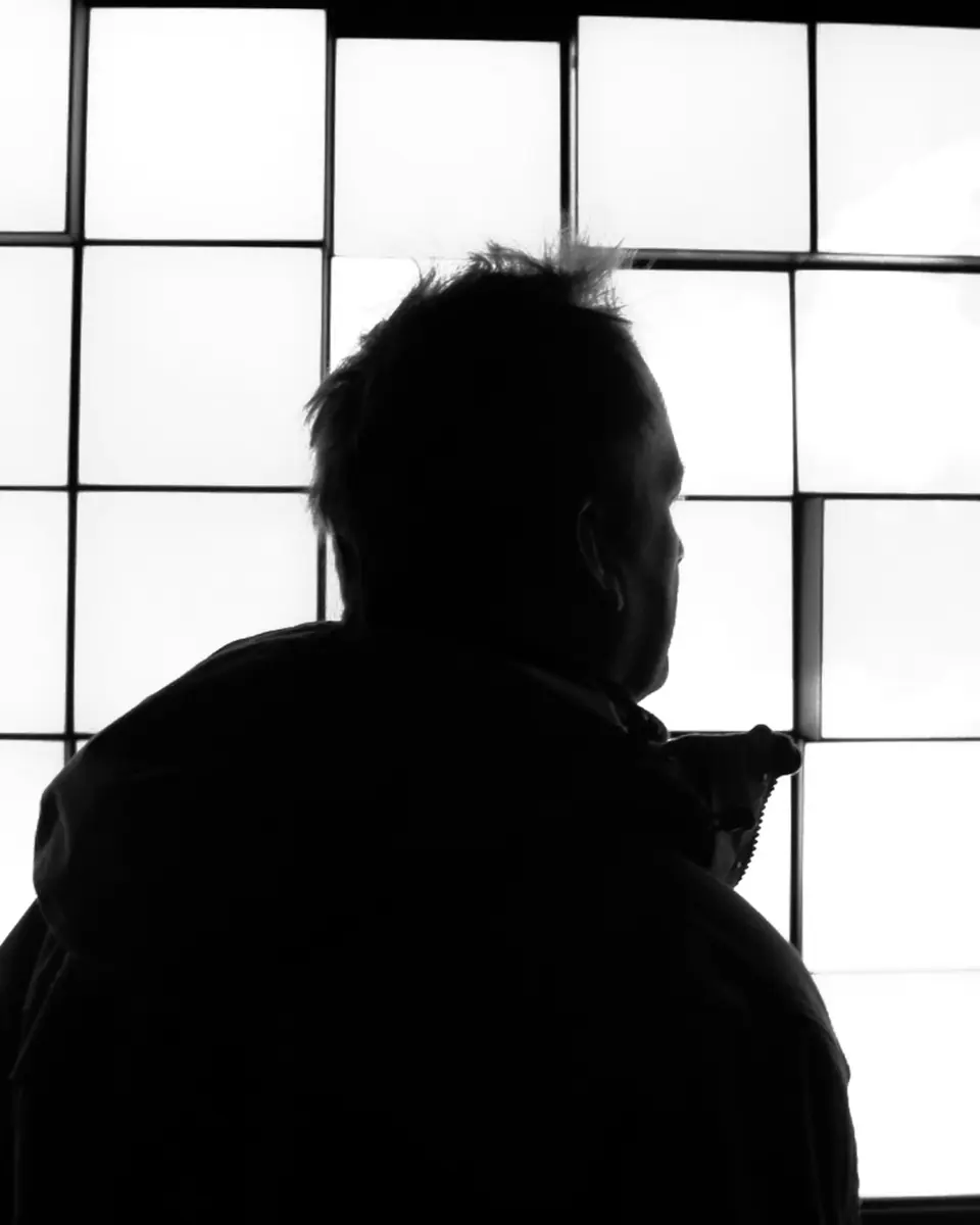 A man silhouetted against a wall of glowing screens