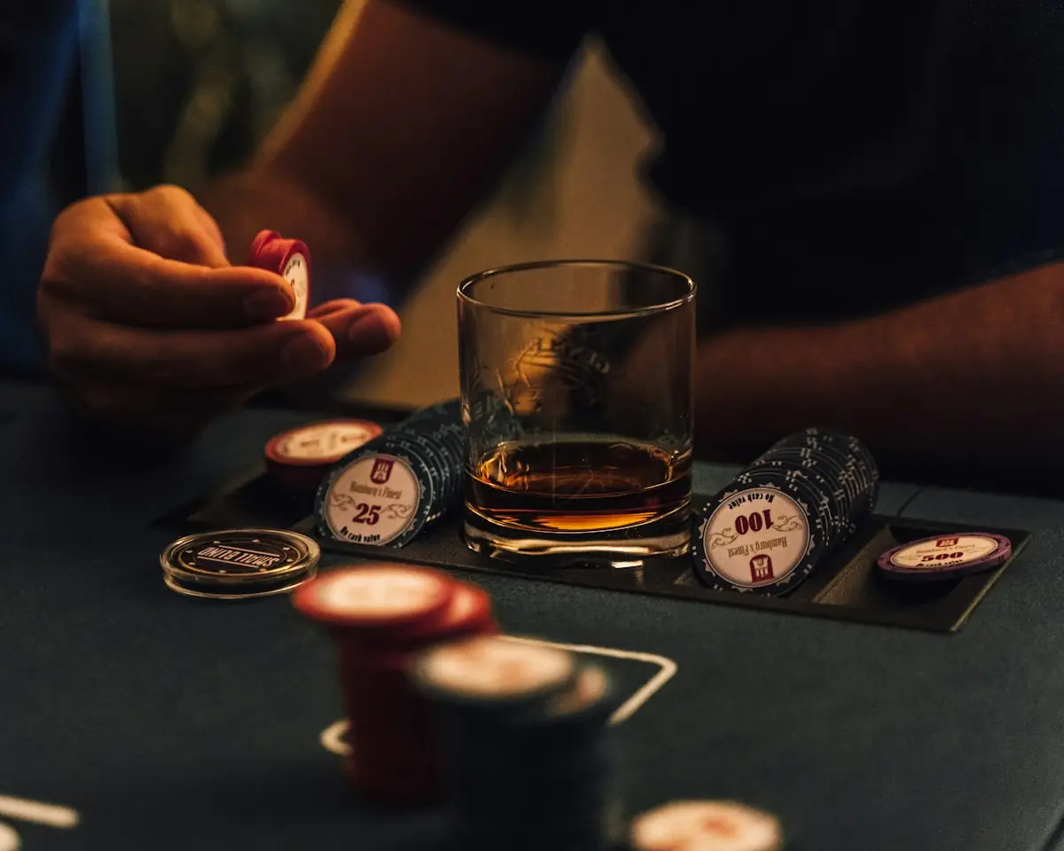 Poker chips and a glass of whisky on a card table