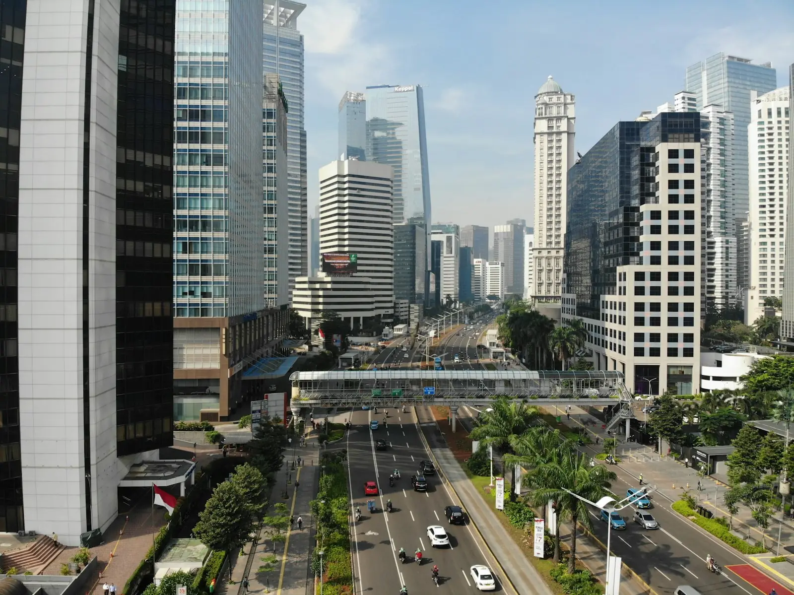 A busy multi-lane road and pedestrian bridge in Jakarta