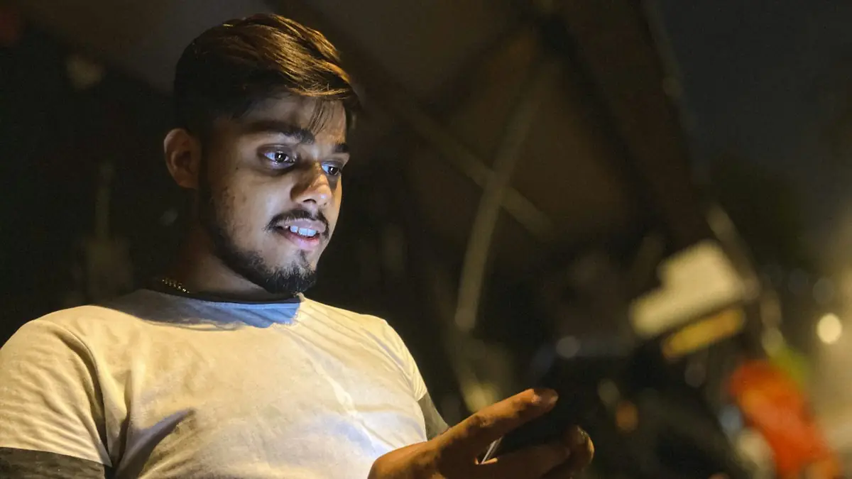A young man in India checking his phone at night