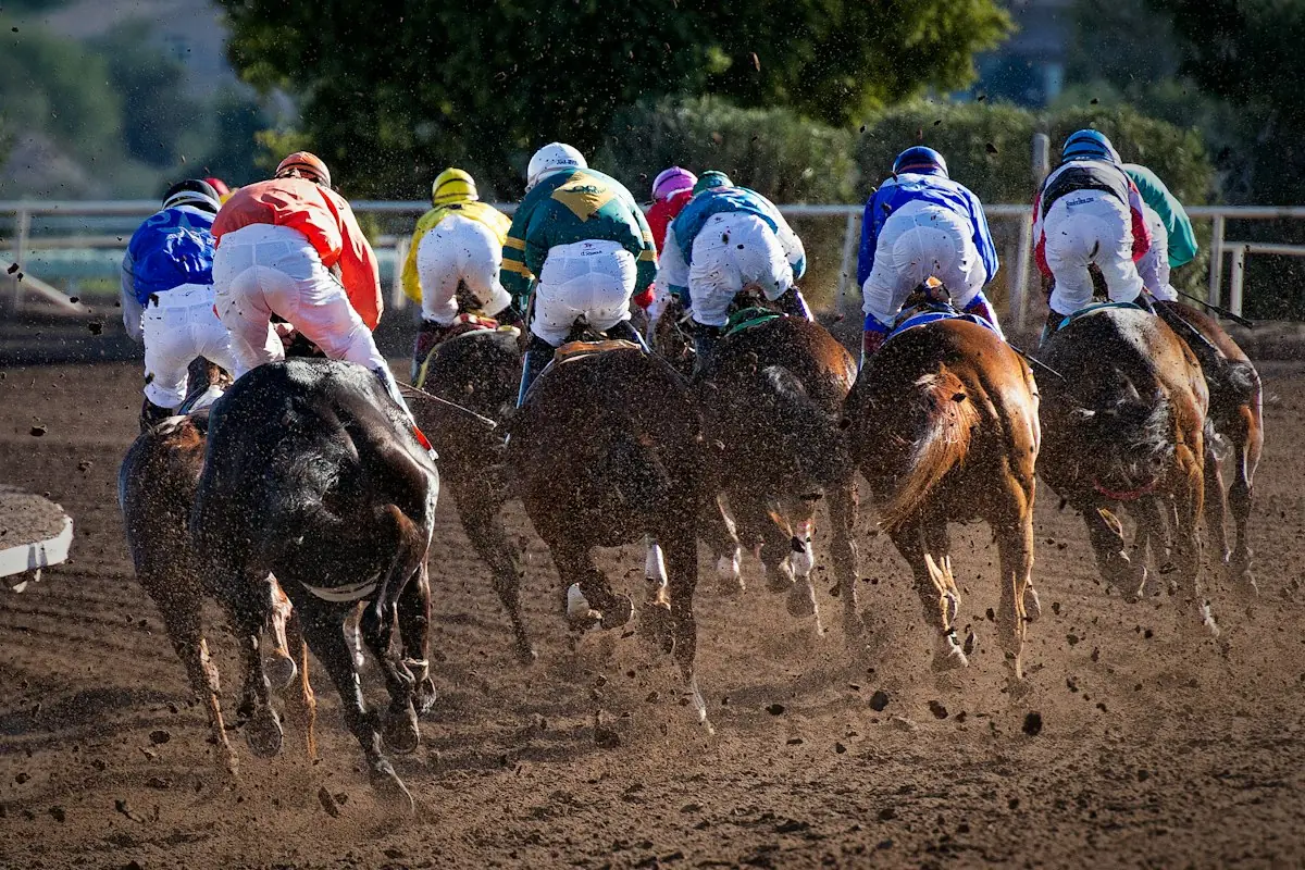 Jockeys racing horses on a dirt track