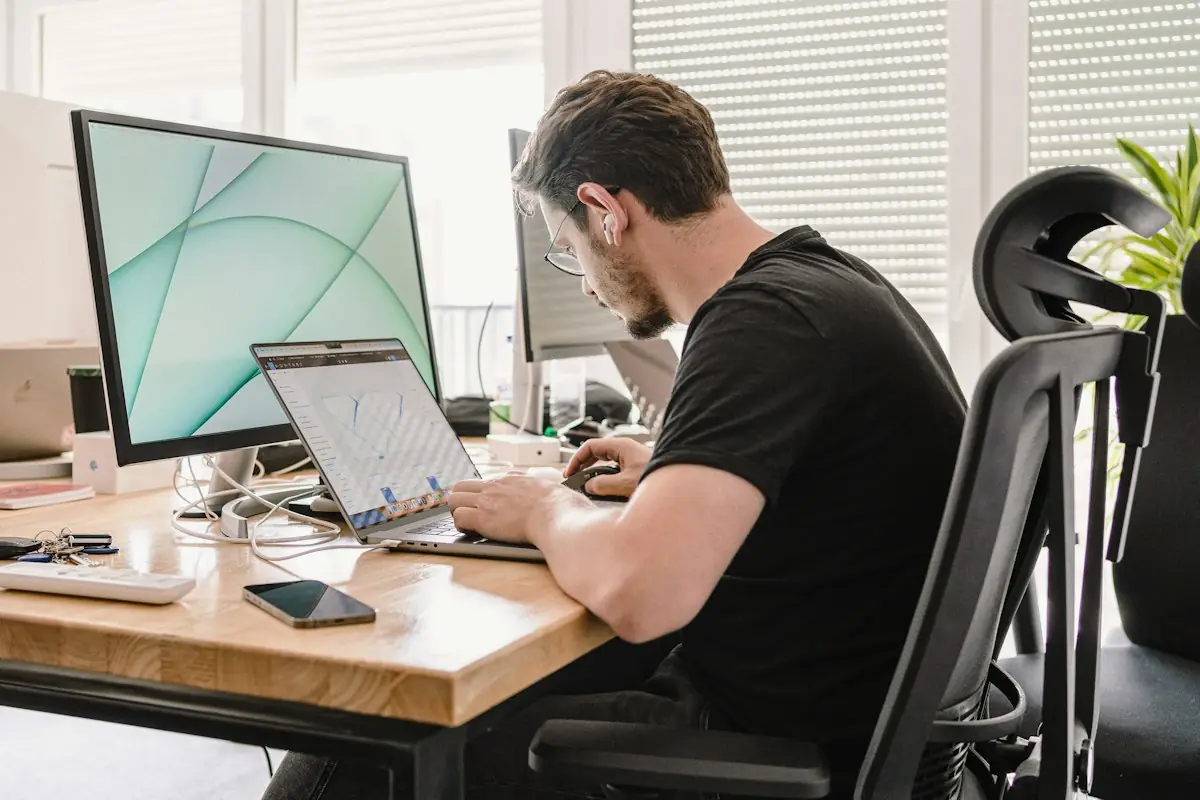 A man working at a desk with a large monitor