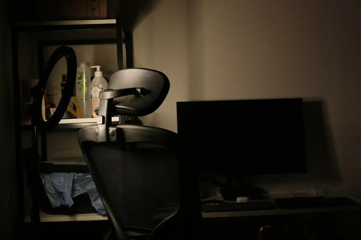 A gaming chair and monitor in a dim room