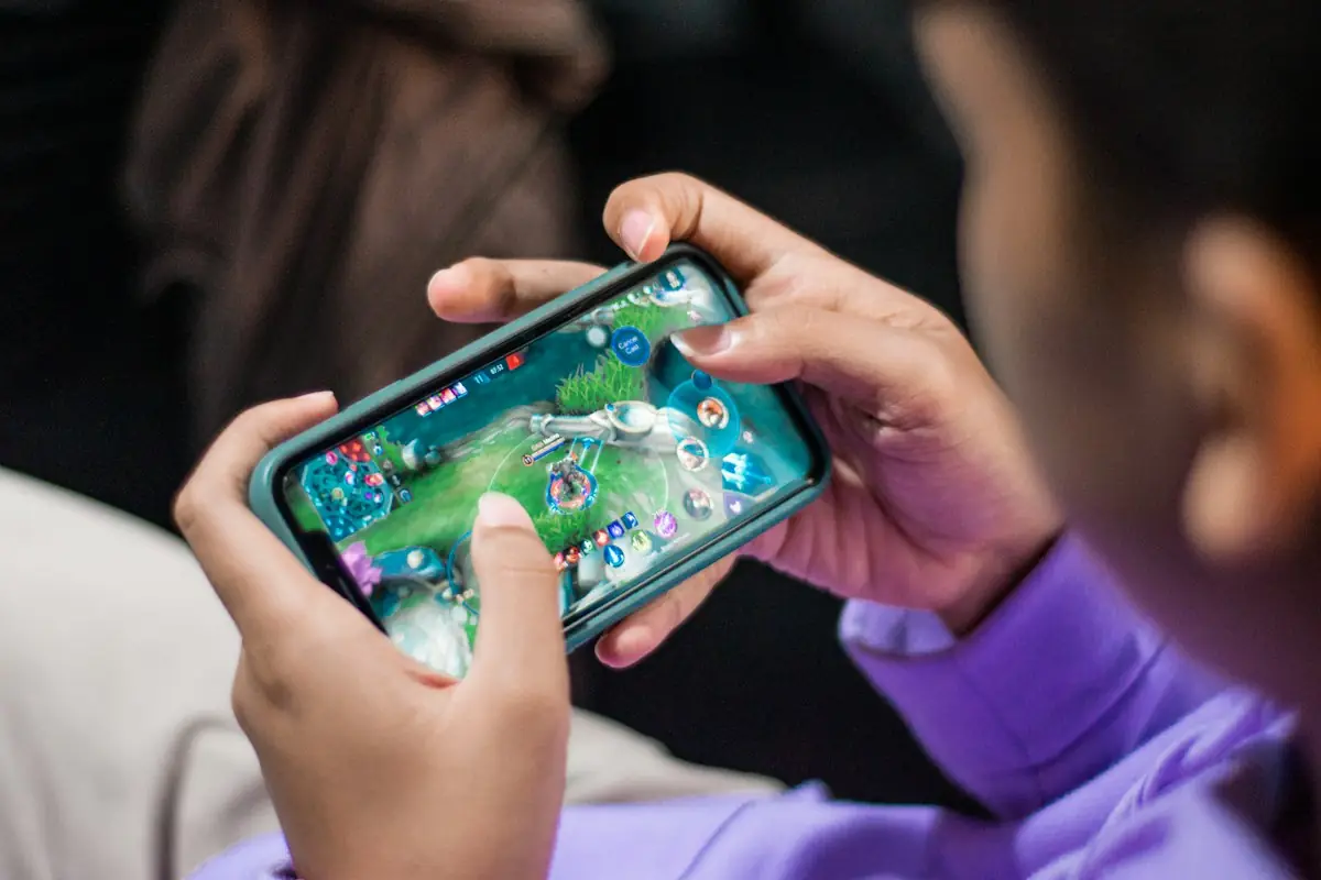 A young player gripping a phone during a mobile game
