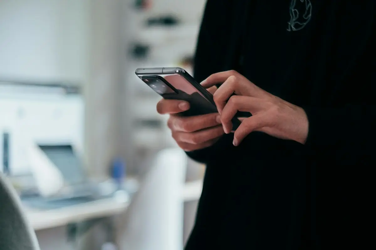 Hands typing a message on a phone