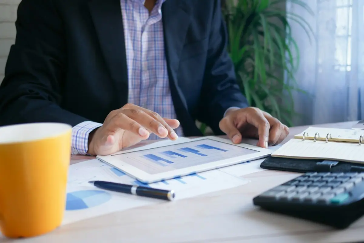 A finance report, tablet and calculator on a desk