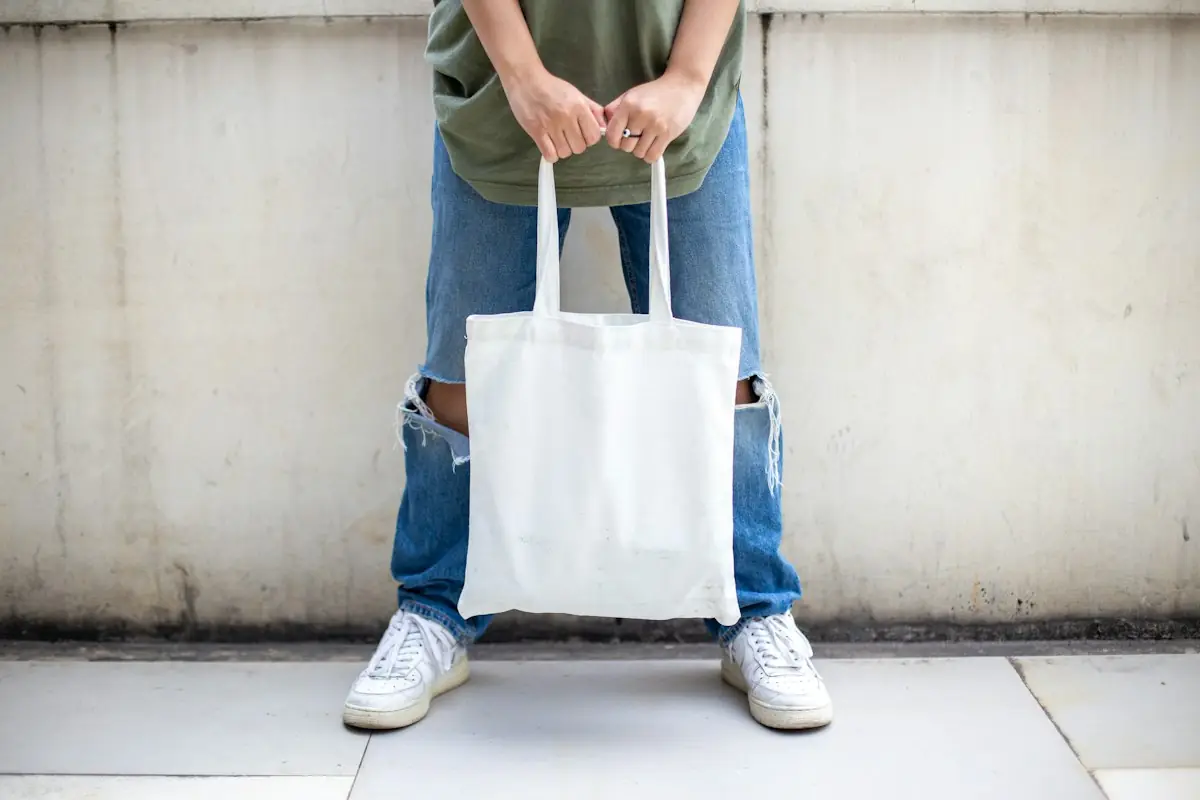 Someone holding a plain white tote bag
