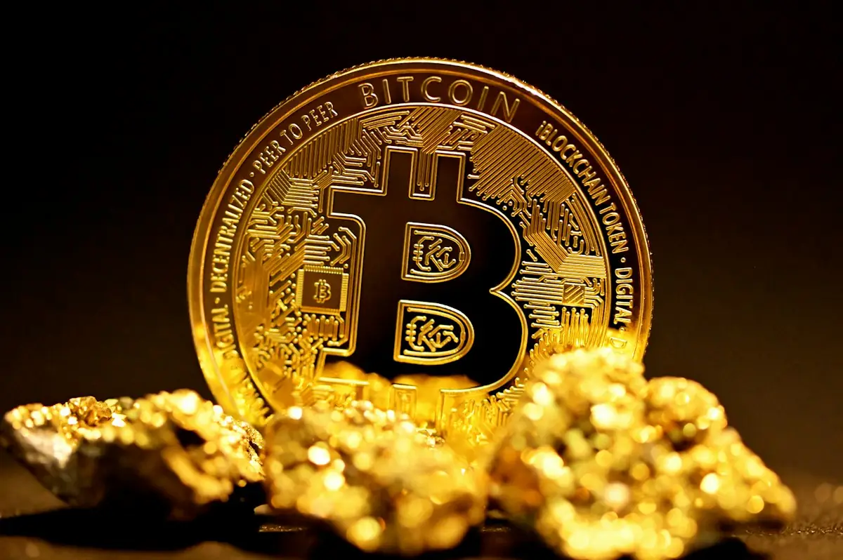 A bitcoin coin resting on gold nuggets