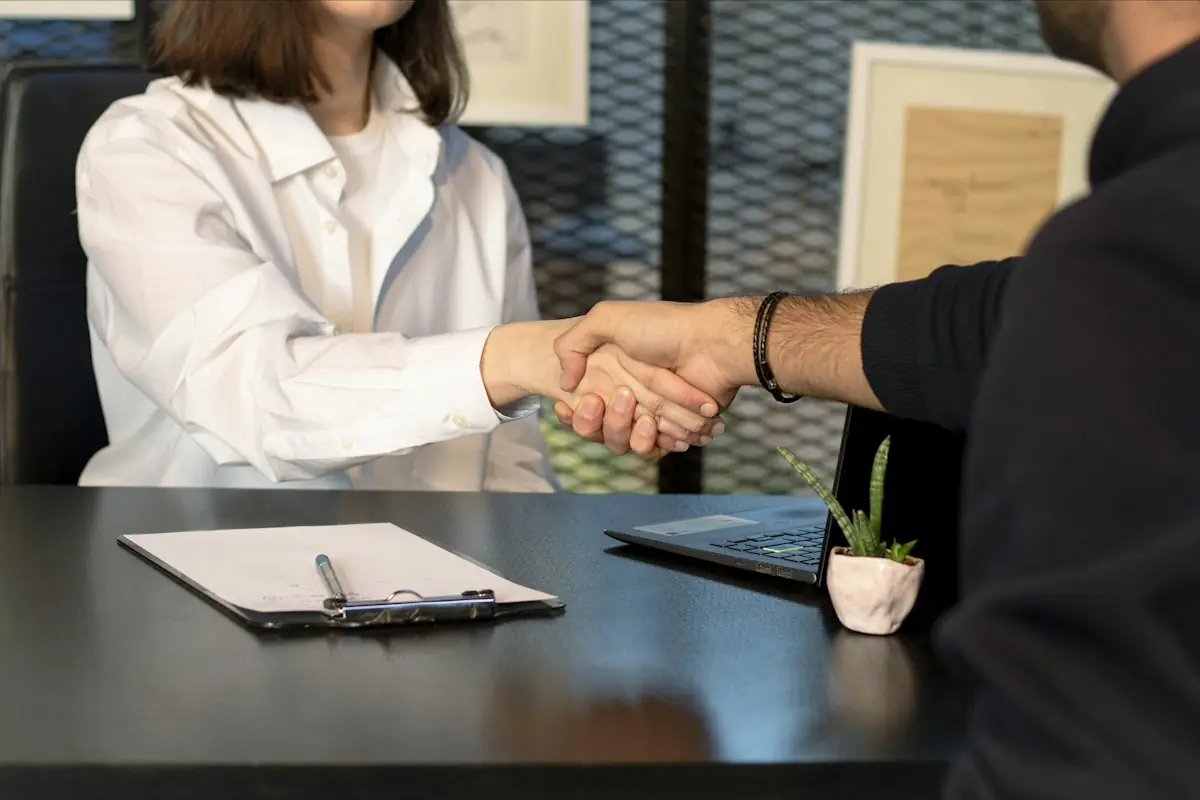Business partners shaking hands across a desk