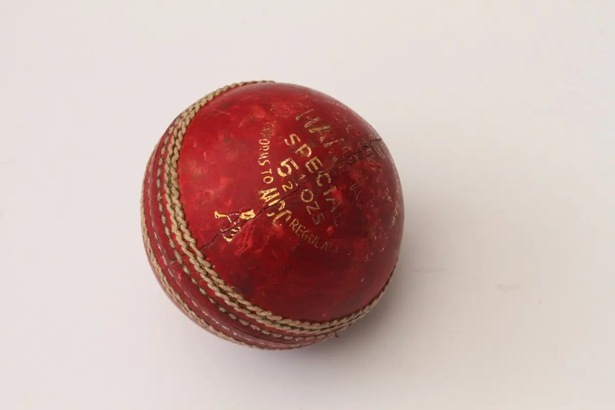 A red cricket ball on a white background