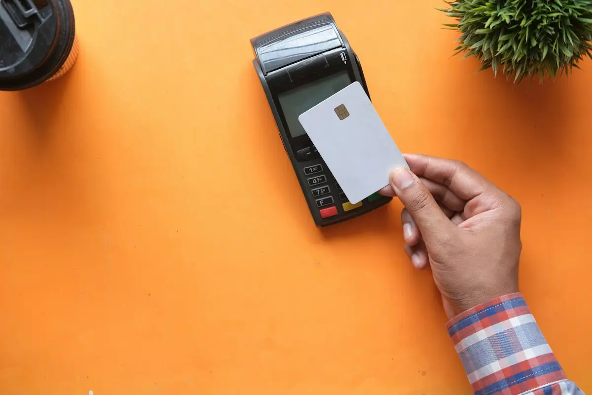 A card held to a payment terminal on an orange table