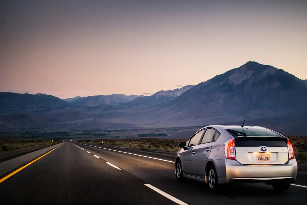 A car on an open road toward the mountains