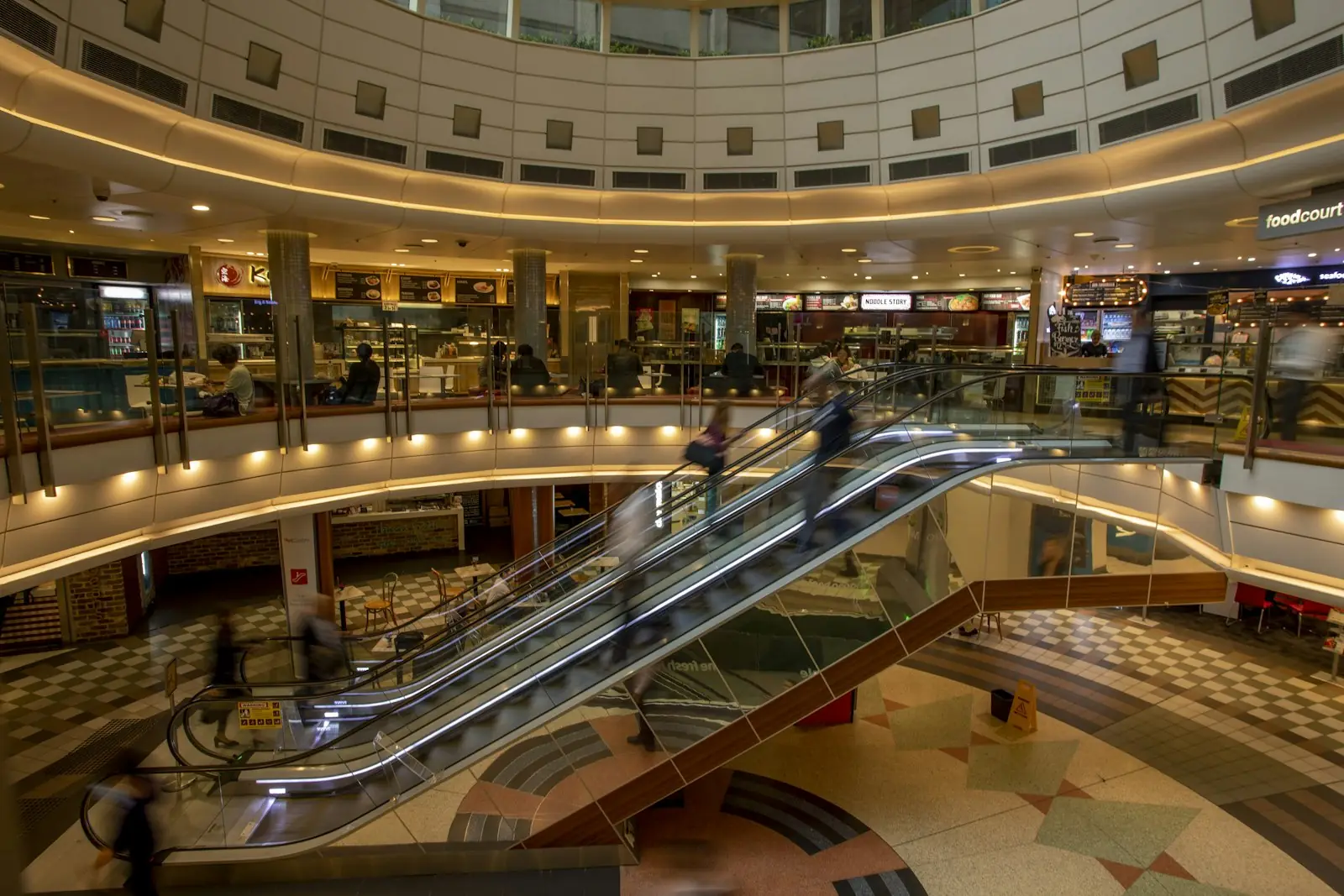 Escalators in a busy shopping mall