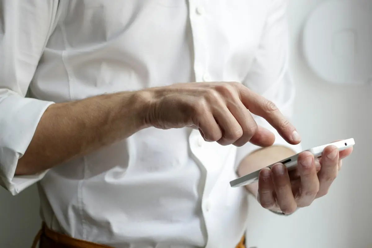 A man in a white shirt shopping on his phone