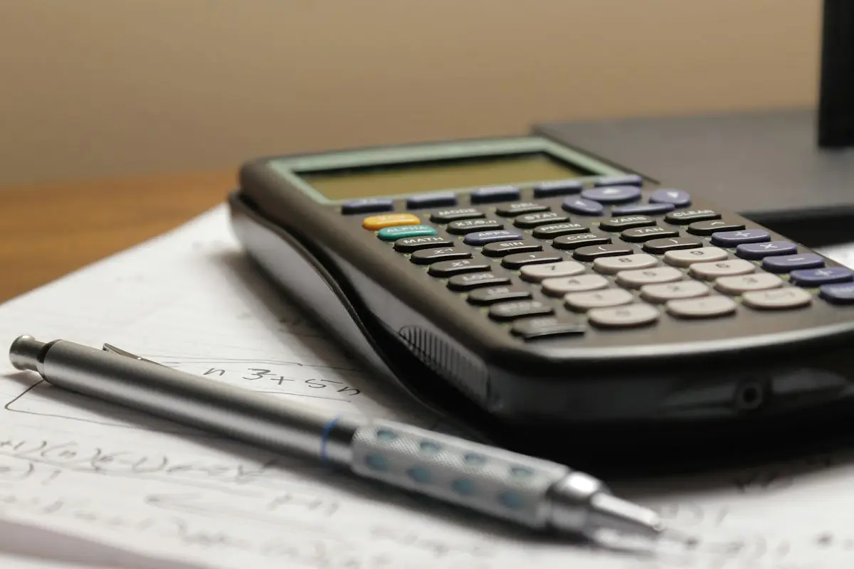 A calculator and pen on a page of figures