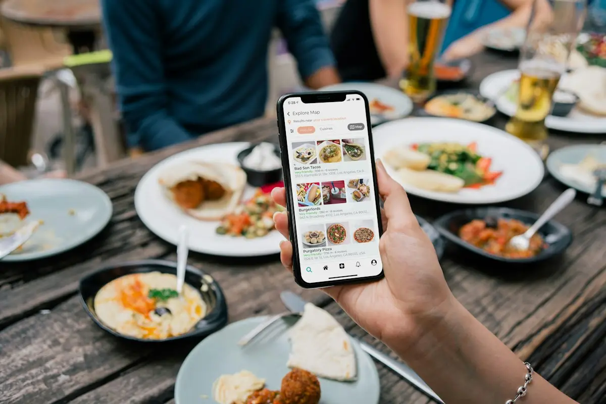 Ordering food on a phone at a table full of dishes
