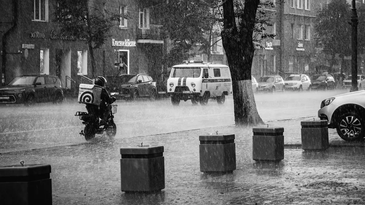 A scooter rider in heavy rain on a city street