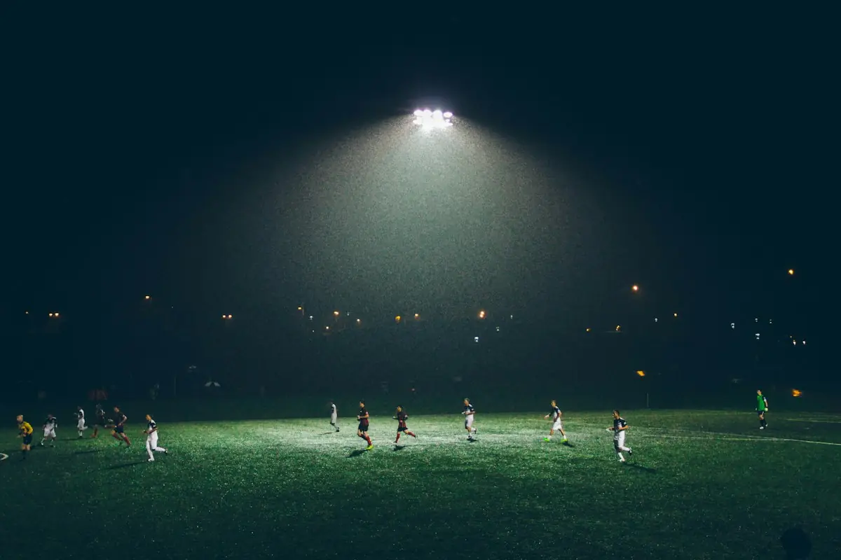 A night football match under a single floodlight
