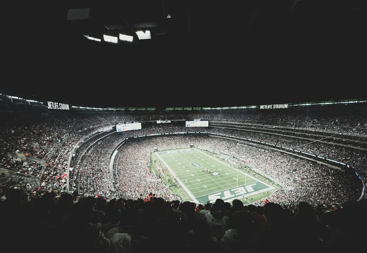 A packed American football stadium under the lights