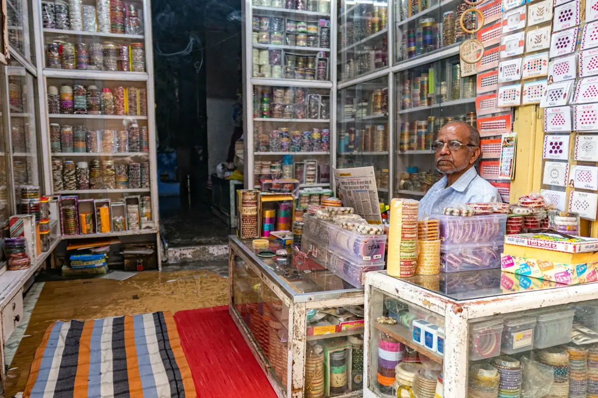 A shopkeeper behind the counter of a busy general store