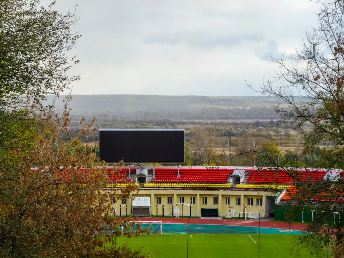 A stadium scoreboard above rows of red seats
