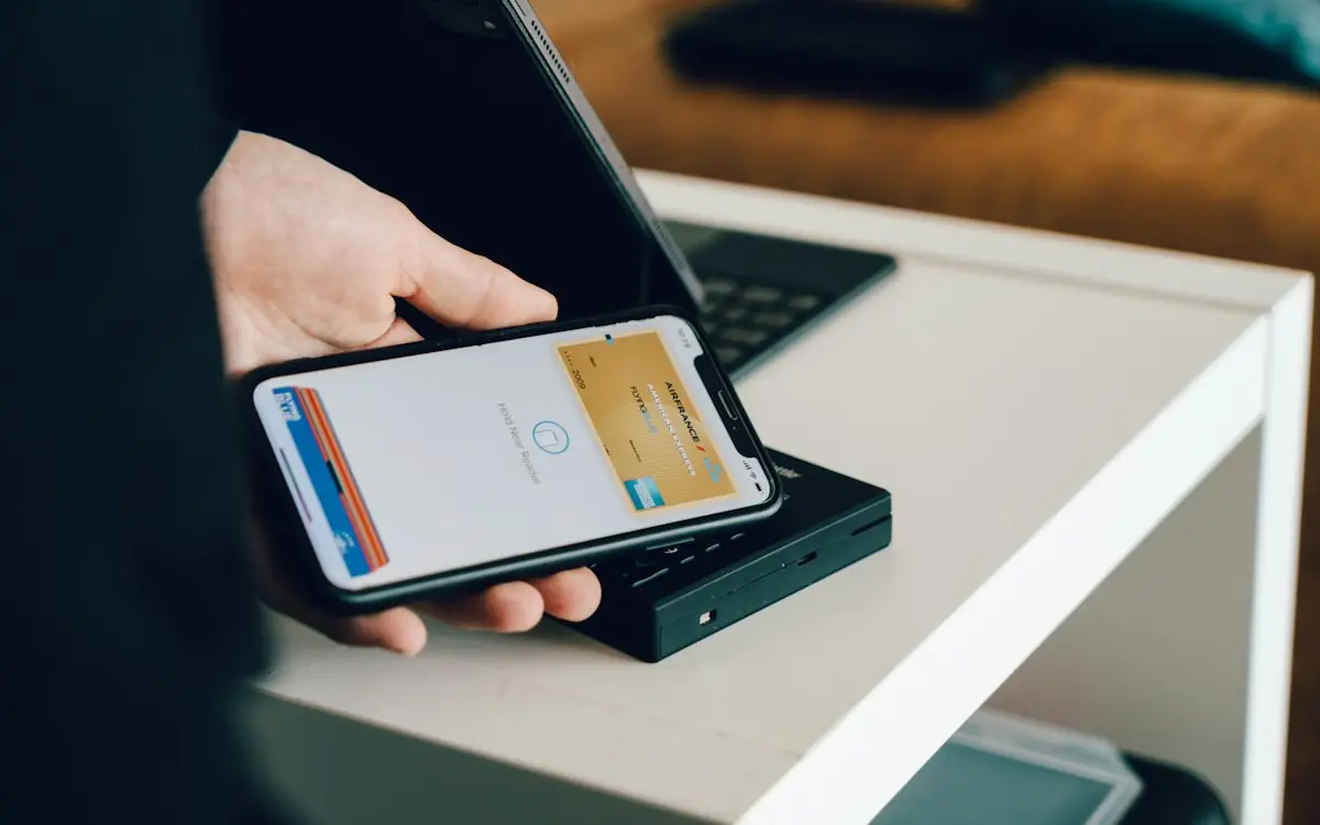 A phone held over a card reader to pay