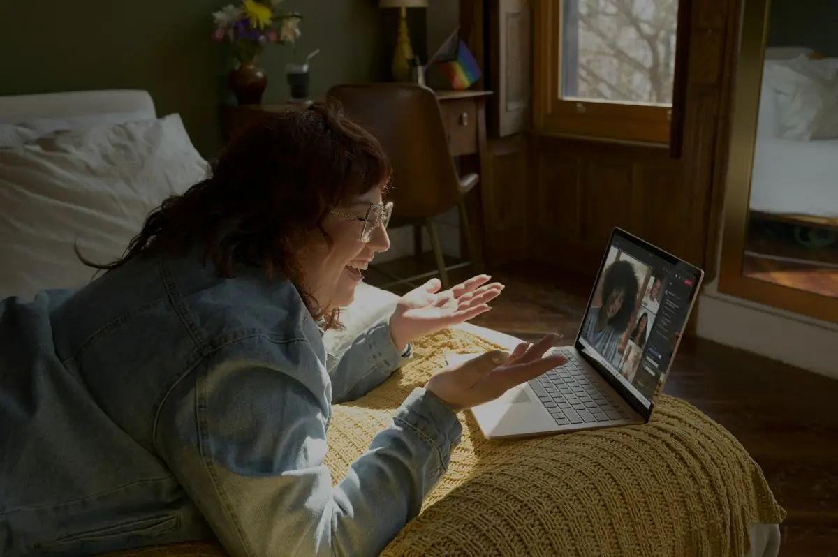 A woman on a video call from her bed