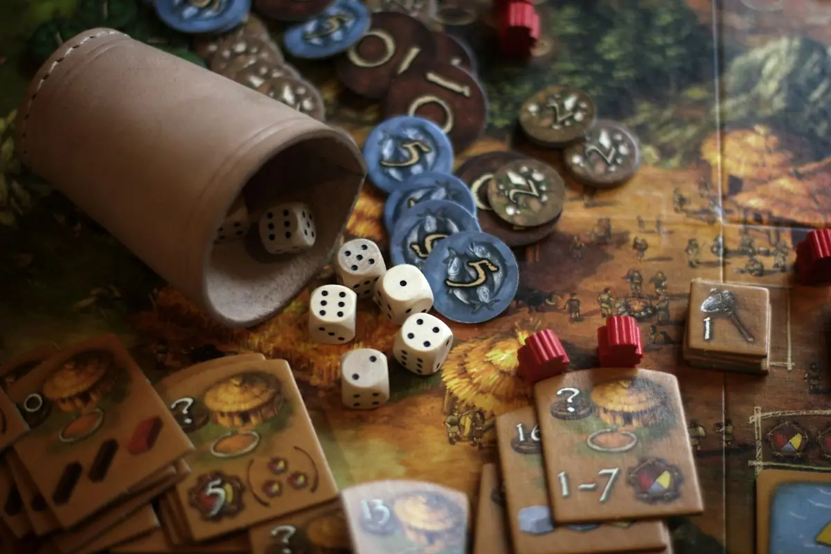 Board game pieces, dice and a cup on a table