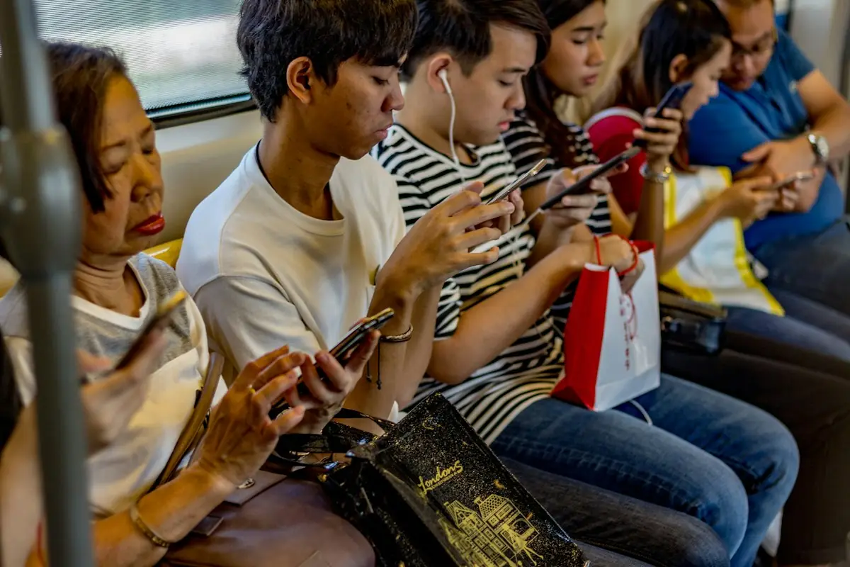 Young people playing games on their phones on a train