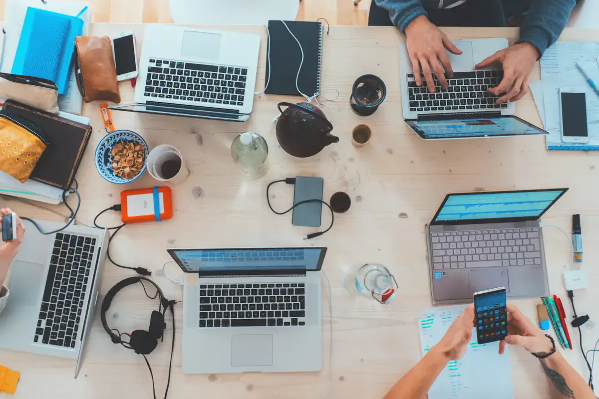 Overhead view of a team working across laptops and phones