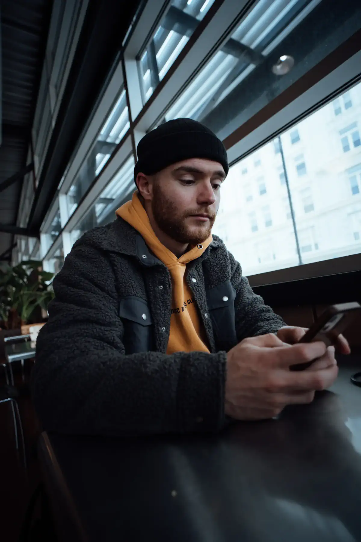 A man checking his phone at a café table
